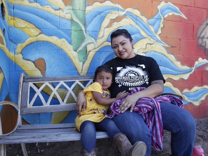 厨师Maria Parra Cano休息一下，持有她3岁的女儿Yalehua。2016年10月10日在菲尼克斯的土着人民一天庆典准备豆类，南瓜，鹿和北美野牛。（由Laura Gomebz /亚利桑那共和国）链接到http://www.azcentral.com/story/新闻/当地/凤凰城/ 2016/10 / 10 / PHOENIX-CELEMATES-INDIGENOUS-PEOPLES-DAY / 91880328 /