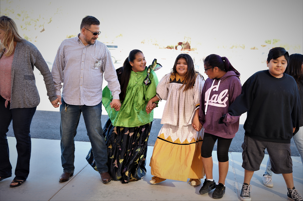 学生，工作人员和家人于2019年在盐河小学参加圆形舞蹈。照片由盐河学校提供